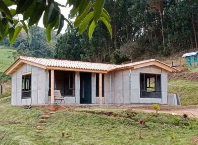 Casa prefabricada en forma de L con jardín y patio central CONCASAYA